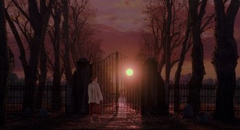 Movie still from “Hocus Pocus” (1993), directed by Kenny Ortega – A person standing in front of a gate at sunset; Wide shot, High angle