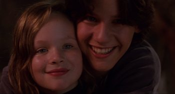 Movie still from “Hocus Pocus” (1993), directed by Kenny Ortega – A woman and a child smiling for the camera; Close Up shot, Low angle