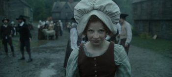 Movie still from “Hocus Pocus 2” (2022), directed by Anne Fletcher – A young girl wearing a hat in a medieval setting; Medium shot, Low angle