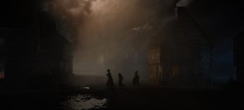 Movie still from “Hocus Pocus 2” (2022), directed by Anne Fletcher – Three people are walking in the fog in a dark city; Extreme Wide shot, High angle