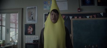 Movie still from “Hocus Pocus 2” (2022), directed by Anne Fletcher – A man wearing a banana costume in a classroom; Medium shot, Over the shoulder angle