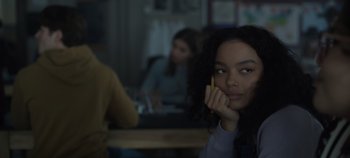 Movie still from “Hocus Pocus 2” (2022), directed by Anne Fletcher – A woman holding a pencil while sitting in front of a table; Close Up shot, Over the shoulder angle