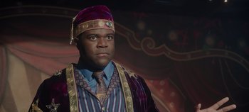 Movie still from “Hocus Pocus 2” (2022), directed by Anne Fletcher – A man wearing a purple and gold hat and suit; Close Up shot, Low angle