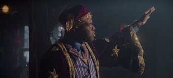 Movie still from “Hocus Pocus 2” (2022), directed by Anne Fletcher – A man in a purple and gold suit and a hat; Medium shot, Low angle