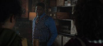 Movie still from “Hocus Pocus 2” (2022), directed by Anne Fletcher – A man standing in front of a shelf of books; Medium shot, Over the shoulder angle