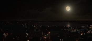 Movie still from “Hocus Pocus 2” (2022), directed by Anne Fletcher – A full moon is setting over a city at night; Extreme Wide shot, High angle