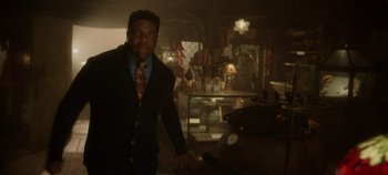 Movie still from “Hocus Pocus 2” (2022), directed by Anne Fletcher – A man wearing a suit and tie standing in a kitchen; Medium shot, Low angle