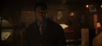 Movie still from “Hocus Pocus 2” (2022), directed by Anne Fletcher – A man wearing a suit and tie standing in a room; Close Up shot, Over the shoulder angle