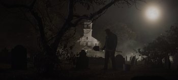 Movie still from “Hocus Pocus 2” (2022), directed by Anne Fletcher – A man holding an axe in the dark; Wide shot, Low angle