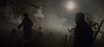 Movie still from “Hocus Pocus 2” (2022), directed by Anne Fletcher – A cemetery with a church in the background at night; Wide shot, Over the shoulder angle