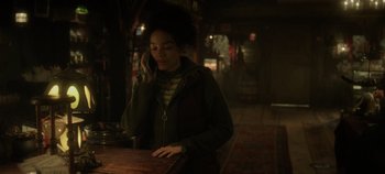Movie still from “Hocus Pocus 2” (2022), directed by Anne Fletcher – A woman talking on a cell phone while standing at a bar; Medium shot, Low angle