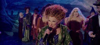 Movie still from “Hocus Pocus 2” (2022), directed by Anne Fletcher – A group of people dressed up as the sanderson sisters from hocus pocus; Medium shot, Over the shoulder angle