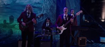 Movie still from “Hocus Pocus 2” (2022), directed by Anne Fletcher – A group of men in suits and ties playing musical instruments; Wide shot, Low angle