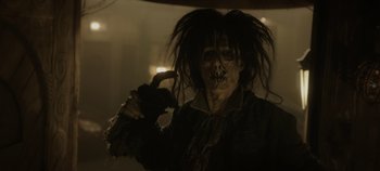 Movie still from “Hocus Pocus 2” (2022), directed by Anne Fletcher – A person with a creepy face paint and a long black hair wig; Close Up shot, Over the shoulder angle