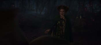 Movie still from “Hocus Pocus 2” (2022), directed by Anne Fletcher – A woman dressed as hocus pocus character winifred in a forest; Medium shot, Over the shoulder angle