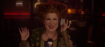 Movie still from “Hocus Pocus 2” (2022), directed by Anne Fletcher – A woman with red curly hair holding a cell phone; Close Up shot, Overhead angle