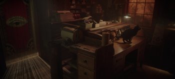Movie still from “Hocus Pocus 2” (2022), directed by Anne Fletcher – A wooden table in a dark room with boxes and papers on it; Wide shot, High angle