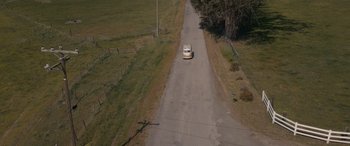 Movie still from “Holiday Harmony” (2022), directed by Shaun Paul Piccinino – An aerial view of a van driving down a rural road; Extreme Wide shot, High angle
