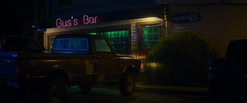 Movie still from “Holiday Harmony” (2022), directed by Shaun Paul Piccinino – A truck parked in front of a bar at night; Wide shot, Low angle