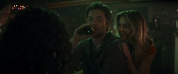 Movie still from “Holiday Harmony” (2022), directed by Shaun Paul Piccinino – A man drinking a beer in front of a woman; Close Up shot, Over the shoulder angle