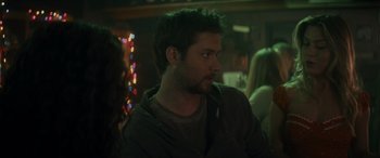 Movie still from “Holiday Harmony” (2022), directed by Shaun Paul Piccinino – A man with a beard is sitting at a bar; Close Up shot, Over the shoulder angle