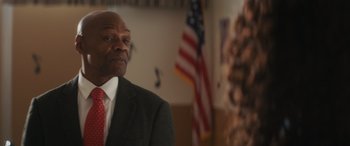 Movie still from “Holiday Harmony” (2022), directed by Shaun Paul Piccinino – A man in a suit and a red neck tie; Close Up shot, Over the shoulder angle