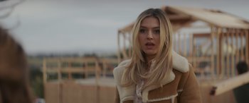 Movie still from “Holiday Harmony” (2022), directed by Shaun Paul Piccinino – A beautiful blond haired woman wearing a shearling coat; Close Up shot, Low angle