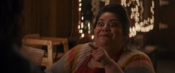 Movie still from “Holiday Harmony” (2022), directed by Shaun Paul Piccinino – A woman with a surprised look on her face points to the side; Close Up shot, Over the shoulder angle