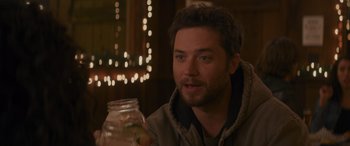 Movie still from “Holiday Harmony” (2022), directed by Shaun Paul Piccinino – A person holding a glass jar; Close Up shot, Over the shoulder angle