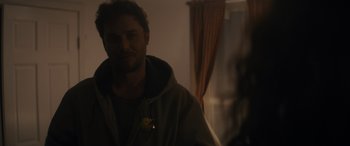 Movie still from “Holiday Harmony” (2022), directed by Shaun Paul Piccinino – A man standing in front of a mirror in a room; Close Up shot, Over the shoulder angle