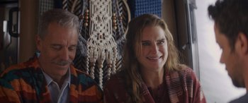 Movie still from “Holiday Harmony” (2022), directed by Shaun Paul Piccinino – A man and a woman smiling for the camera; Close Up shot, Over the shoulder angle