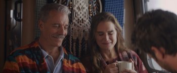 Movie still from “Holiday Harmony” (2022), directed by Shaun Paul Piccinino – A man and a woman sitting next to each other holding a mug; Close Up shot, Over the shoulder angle