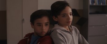 Movie still from “Holiday Harmony” (2022), directed by Shaun Paul Piccinino – Two young children sitting next to each other; Close Up shot, High angle