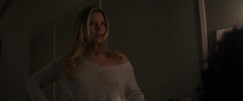 Movie still from “Holiday Harmony” (2022), directed by Shaun Paul Piccinino – A beautiful woman in a white sweater looking at a mirror; Medium shot, Low angle