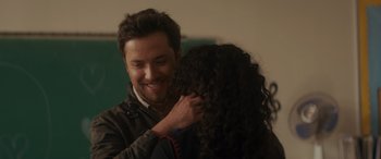 Movie still from “Holiday Harmony” (2022), directed by Shaun Paul Piccinino – A man and a woman smiling at each other; Close Up shot, Over the shoulder angle