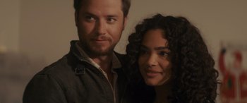 Movie still from “Holiday Harmony” (2022), directed by Shaun Paul Piccinino – A man and a woman pose for a picture; Close Up shot, Over the shoulder angle