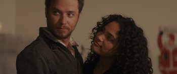 Movie still from “Holiday Harmony” (2022), directed by Shaun Paul Piccinino – A man and a woman pose for a picture; Close Up shot, Over the shoulder angle