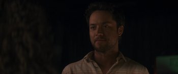 Movie still from “Holiday Harmony” (2022), directed by Shaun Paul Piccinino – A person wearing a plaid shirt; Close Up shot, Over the shoulder angle