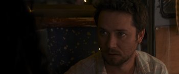 Movie still from “Holiday Harmony” (2022), directed by Shaun Paul Piccinino – A person wearing a shirt; Close Up shot, Over the shoulder angle
