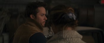 Movie still from “Holiday Harmony” (2022), directed by Shaun Paul Piccinino – A man and a woman sitting next to each other; Close Up shot, Over the shoulder angle