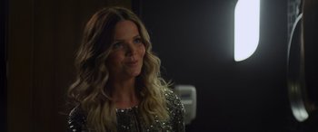 Movie still from “Holiday Harmony” (2022), directed by Shaun Paul Piccinino – A woman with long blonde hair wearing a silver dress; Close Up shot, Over the shoulder angle