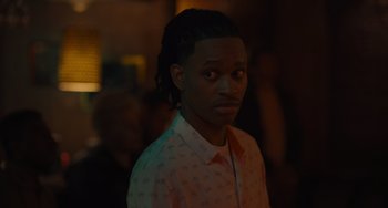 Movie still from “Hollywood Stargirl” (2022), directed by Julia Hart – A young man with long dreadlocks is looking at the camera; Close Up shot, Over the shoulder angle
