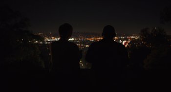 Movie still from “Hollywood Stargirl” (2022), directed by Julia Hart – Two people are looking out over a city at night; Wide shot, Over the shoulder angle