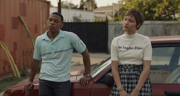 Movie still from “Hollywood Stargirl” (2022), directed by Julia Hart – A man and a woman standing next to a car; Medium shot, Low angle