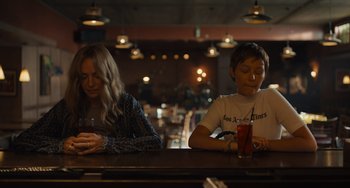 Movie still from “Hollywood Stargirl” (2022), directed by Julia Hart – Two people sitting at a bar looking at their cell phones; Medium shot, Over the shoulder angle