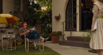 Movie still from “Hollywood Stargirl” (2022), directed by Julia Hart – An older woman sitting on a chair reading a book; Wide shot, Low angle