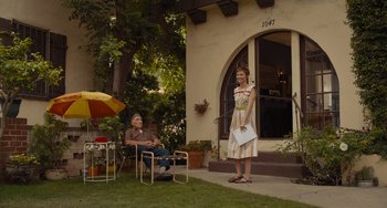 Movie still from “Hollywood Stargirl” (2022), directed by Julia Hart – A woman standing in front of a house next to an older woman; Wide shot, Low angle