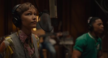 Movie still from “Hollywood Stargirl” (2022), directed by Julia Hart – A young man is recording a song in a recording studio; Close Up shot, Over the shoulder angle