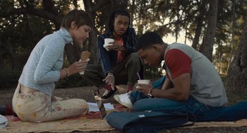 Movie still from “Hollywood Stargirl” (2022), directed by Julia Hart – A group of people sitting on the ground eating food; Medium shot, High angle