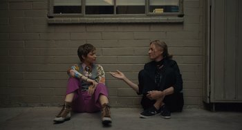 Movie still from “Hollywood Stargirl” (2022), directed by Julia Hart – Two women sitting on the ground talking to each other; Wide shot, High angle